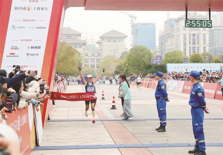 选手冲过终点线，高举双臂庆祝胜利。