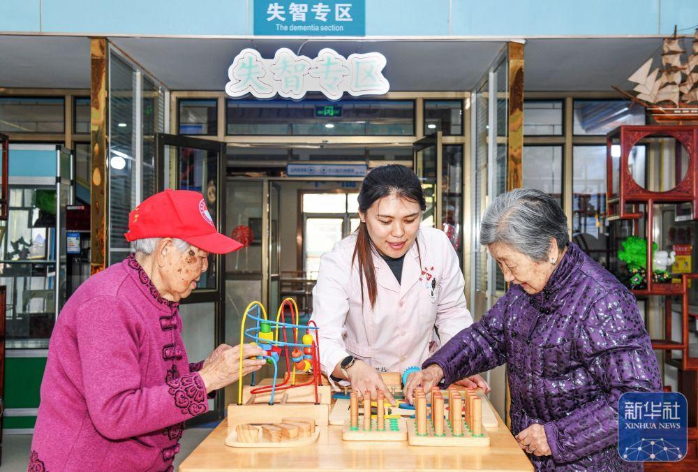 3月25日，在胶州市华福润养护院，护理人员协助老人进行益智训练。新华社发（王昭脉 摄）