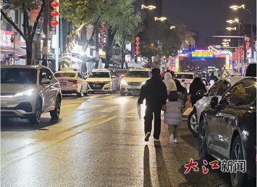 夜幕下的洪都夜巷，路上人车混行。 全媒体记者肖立宇摄