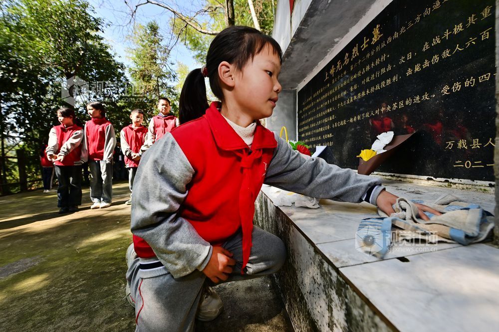 2026年4月1日,在江西省宜春市万载县茭湖乡上峰村革命烈士墓碑前,学生正在墓碑前清扫。