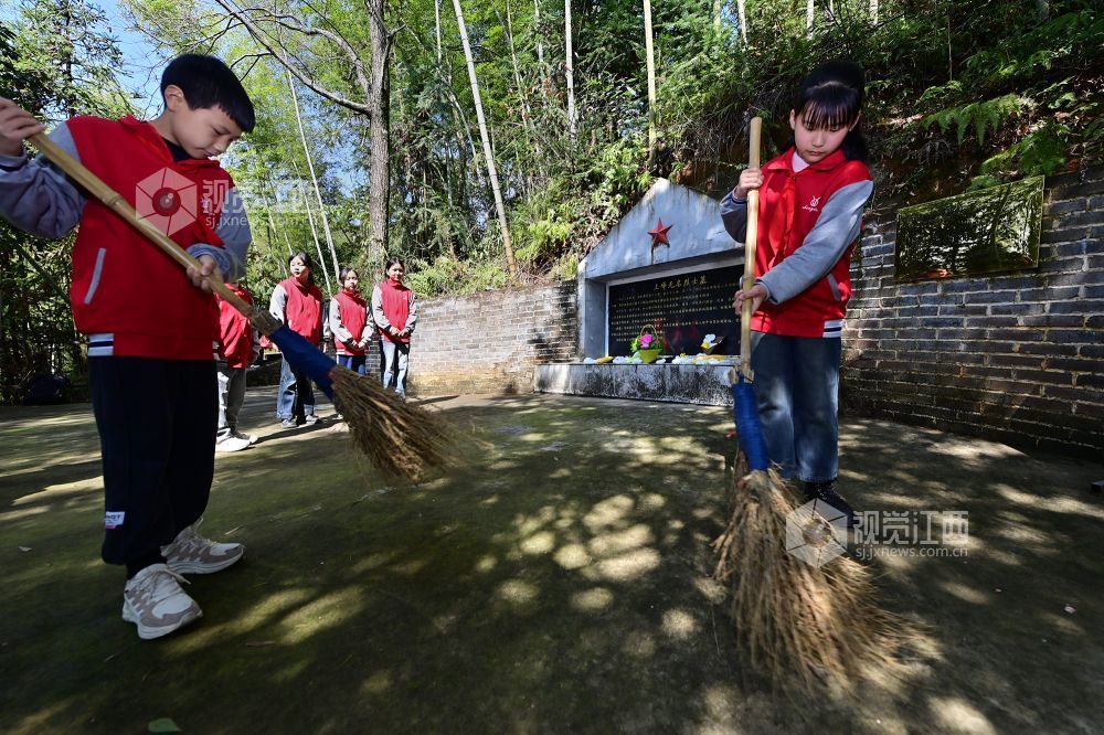 2026年4月1日,在江西省宜春市万载县茭湖乡上峰村革命烈士墓碑前,学生正在墓碑前清扫。