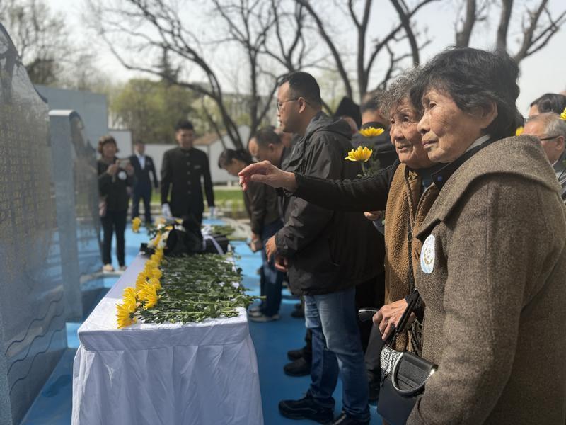 家属代表在纪念墙上找到亲人的名字