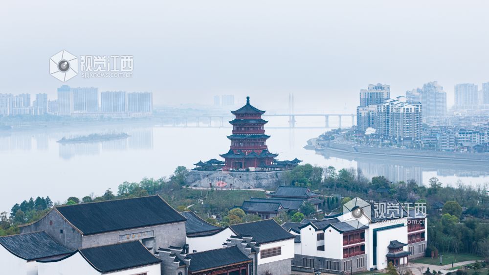 2026年3月30日,江西省吉安市吉水县清晨下完雨后,水面平静得像一面镜子,岸边的建筑倒映在水中与空中的云雾形成一幅江南画卷。