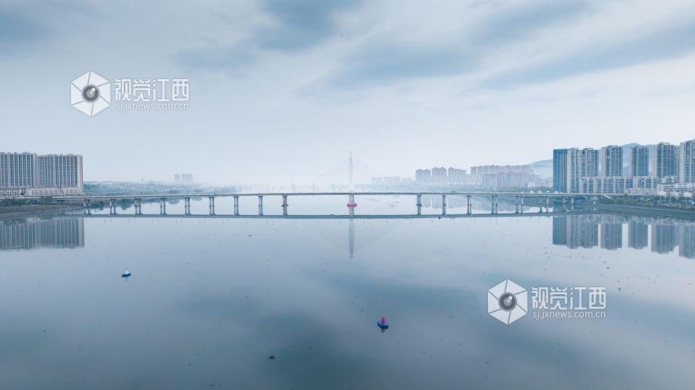 2026年3月30日,江西省吉安市吉水县清晨下完雨后,水面平静得像一面镜子,岸边的建筑倒映在水中与空中的云雾形成一幅江南画卷。