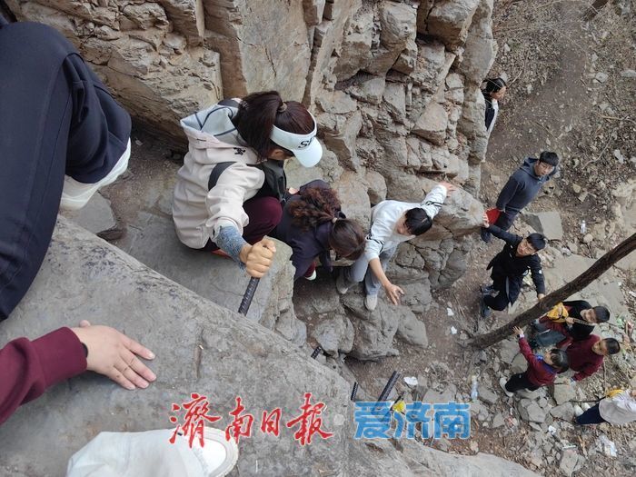 安浩宇(白衣)、王洪波(黑衣)在协助游客下断崖。受访者供图