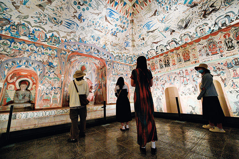 在敦煌石窟文物保护研究陈列中心，游客参观莫高窟复制洞窟第276窟壁画（2024年6月7日摄）　郎兵兵摄/本刊