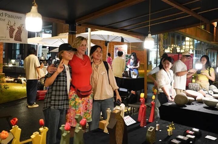 游客在陶溪川春秋大集上与外国艺术家合影留念。新华社记者 周密 摄