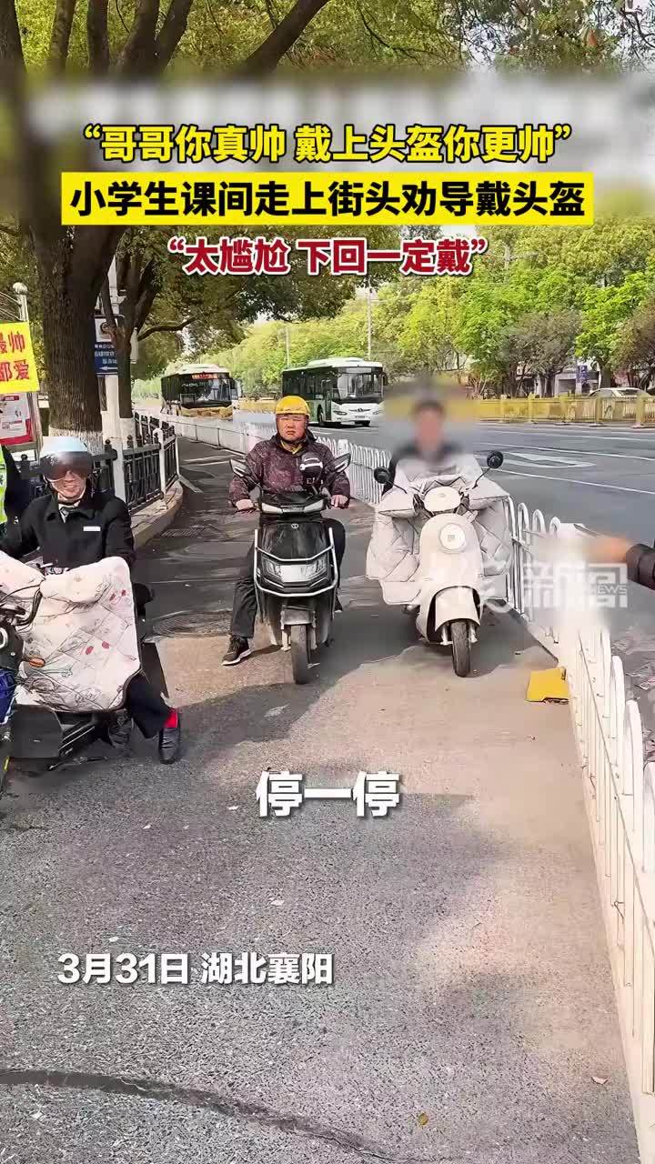 小学生课间走上街头，对未佩戴头盔的市民“花式”劝导。警方提醒：请牢记“小交警”的暖心劝告，骑乘出行务必正确佩戴头盔