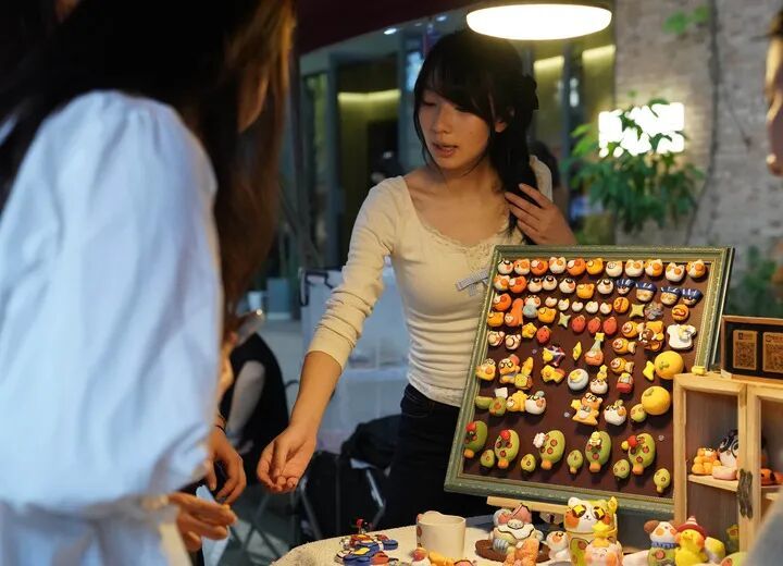 在陶溪川春秋大集上,一位摊主向游客介绍创意瓷器。新华社记者 周密 摄