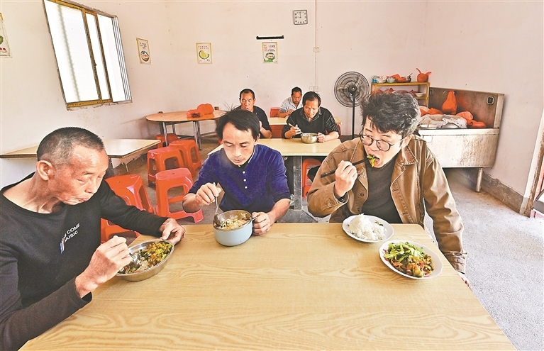 龚著海（右）与村民一起用餐。目前，赣州市力展农业有限公司已带动60余名村民稳定就业。