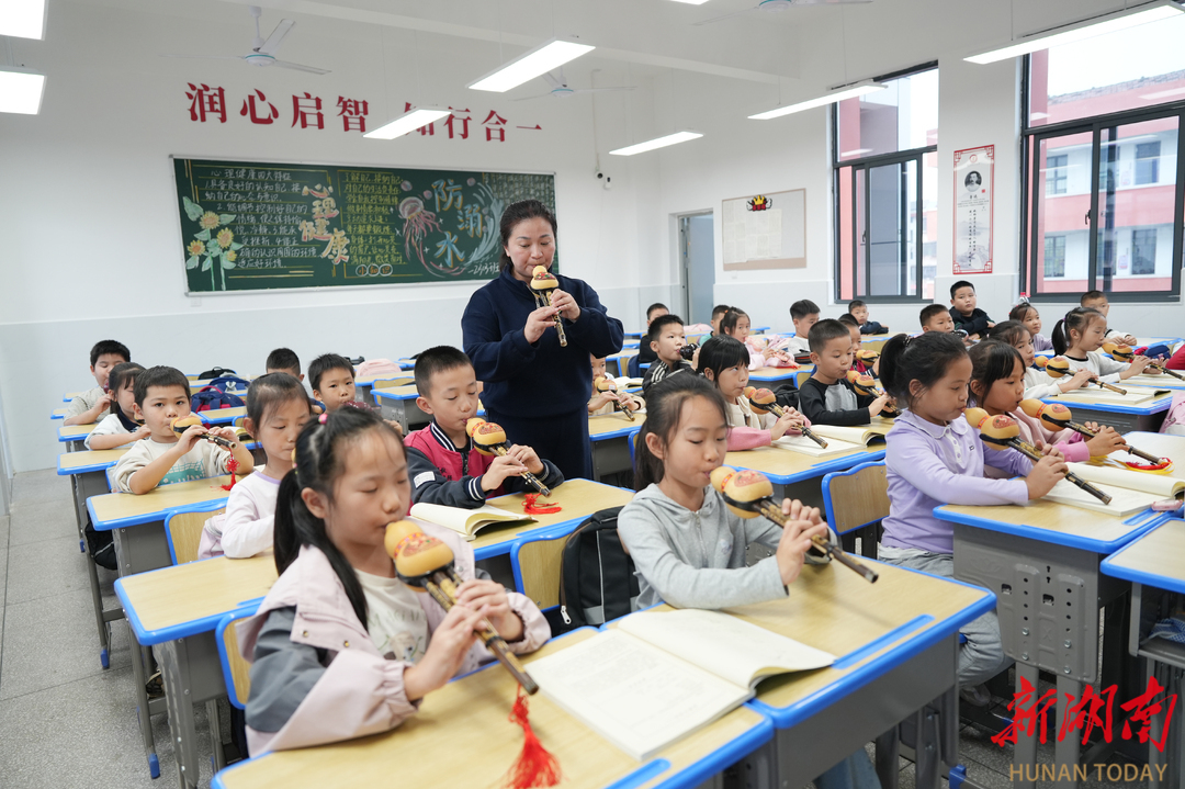 在沅江市南大膳镇中心小学,支教老师刘琳在教学生吹葫芦丝。 雷鸿涛 摄