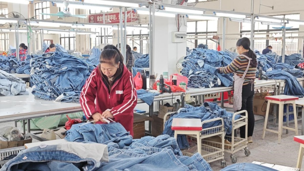 兴国长裕实业有限公司生产车间，工人正在对牛仔服装进行打包。澎湃新闻记者 郑问 摄