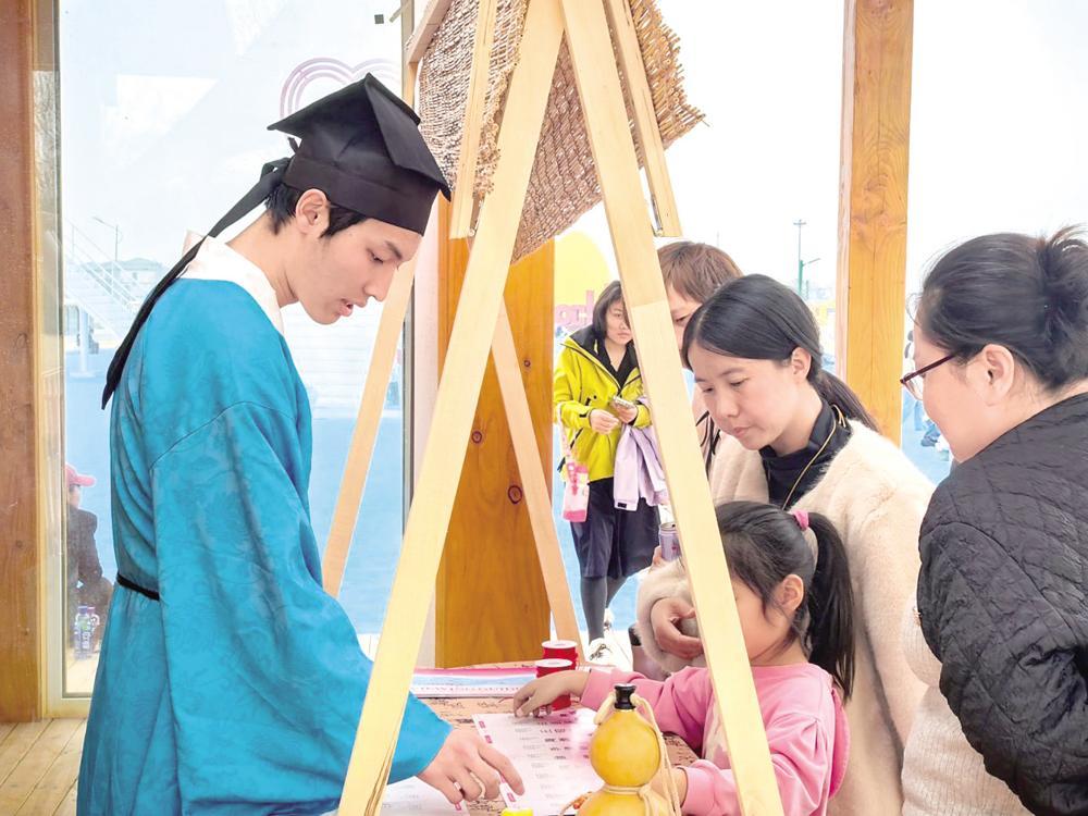 图为游客在塔元庄&middot;乡与集文化街区集章打卡。塔元庄&middot;乡与集文化街区供图