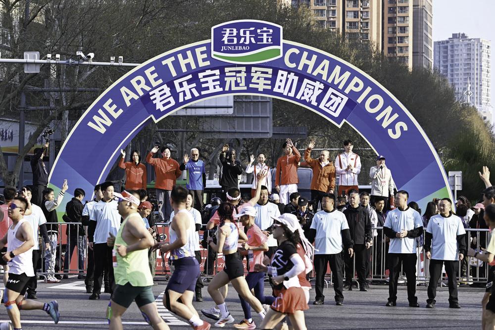 图为冠军助威团为跑友们加油助威。左起高唯中、巩立姣、魏立华、基普乔格、常园、李文淏、栾钰堃、孟明宽。　　 记者 张晓峰 摄