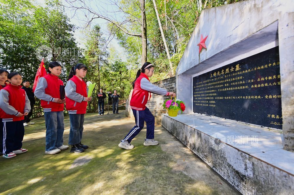 2026年4月1日,在江西省宜春市万载县茭湖乡上峰村革命烈士墓碑前,学生正在敬献花篮鲜花。