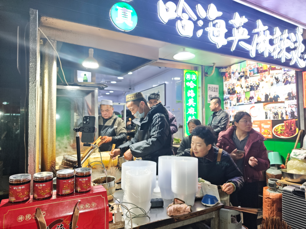 2026年年初的一天，因天水麻辣烫爆火的“表情哥”站在店门口给客人烫菜。本文图除注明外，均为澎湃新闻记者高宇婷摄。