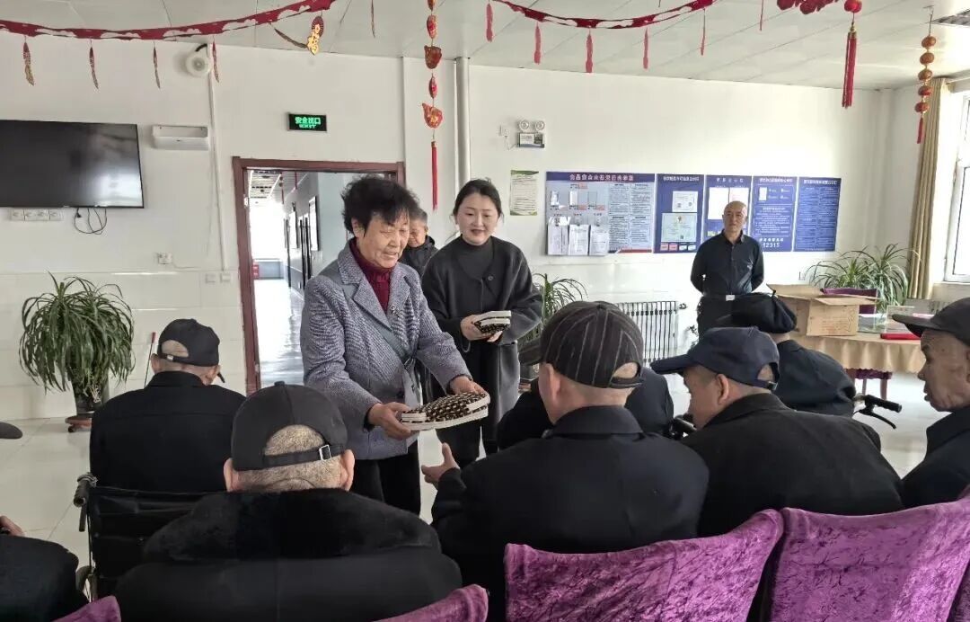 △社区工作人员和黄桂花一同为双湾镇敬老院的老人们送上棉拖鞋