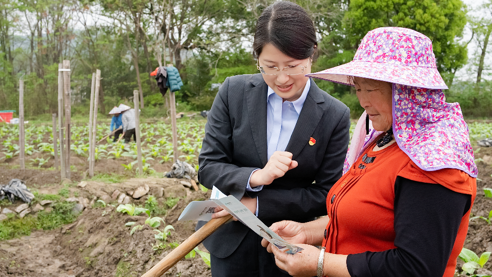 图为农业银行瑞金市支行客户经理向烟叶农户宣讲普惠金融政策