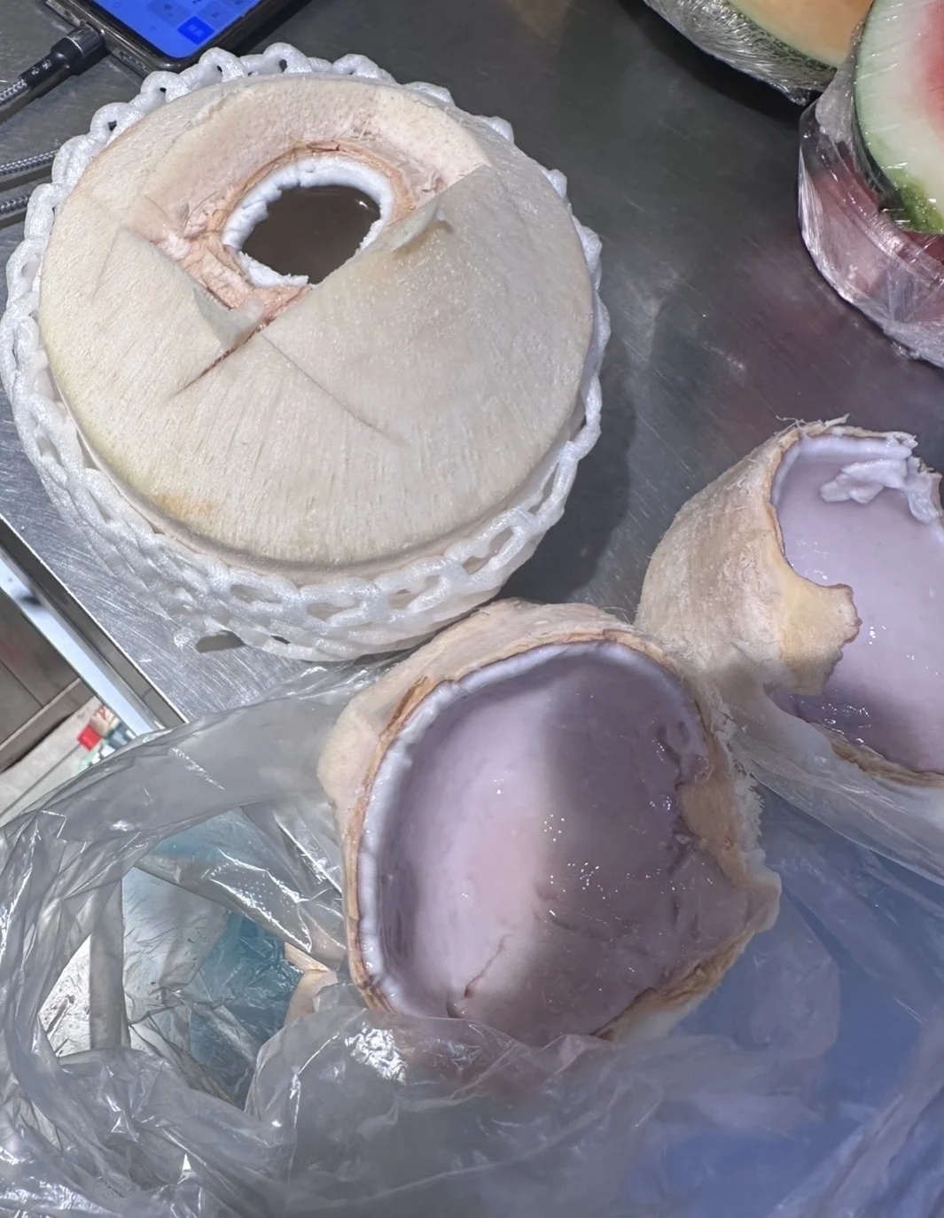 店员随机打开同一批次的椰子(左一)进行对比(来源:当事人供图)