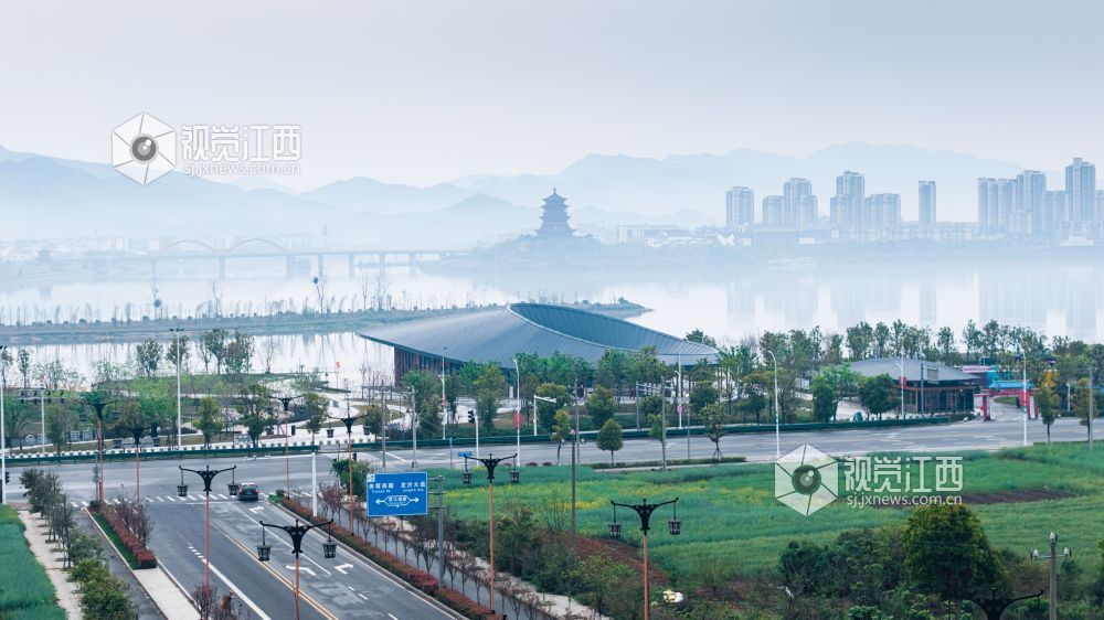 2026年3月30日,江西省吉安市吉水县清晨下完雨后,水面平静得像一面镜子,岸边的建筑倒映在水中与空中的云雾形成一幅江南画卷。