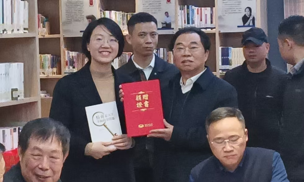 图为：爱心捐赠现场，湖南图书馆副馆长陈姣凤与作者曾昭才先生合影留念。