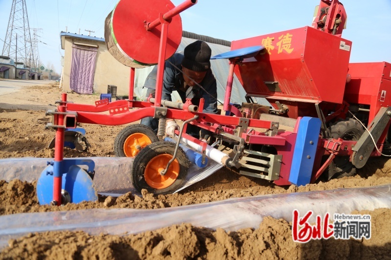 图为农机手在调试马铃薯播种机。吴海民摄