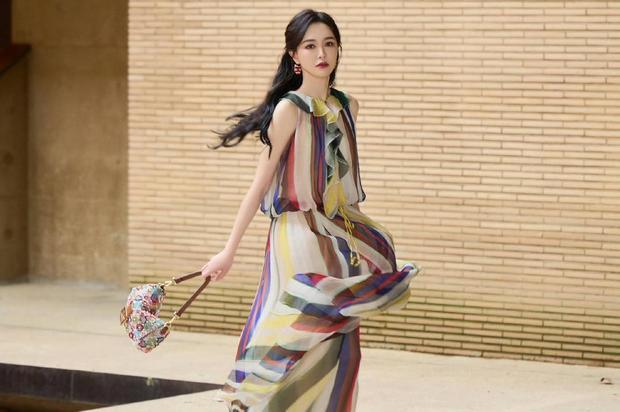 搜狐娱乐讯 唐嫣身着彩条无袖纱裙亮相，裙摆轻盈飘逸，搭配亮彩手袋，造型明媚灵动。