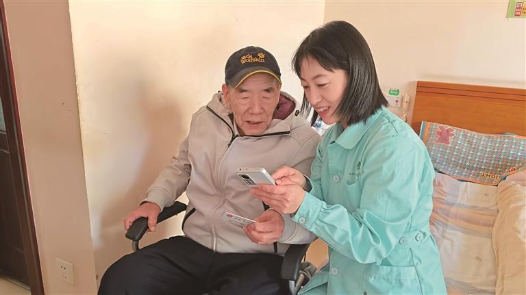 工作人员协助居民申领养老服务消费补贴