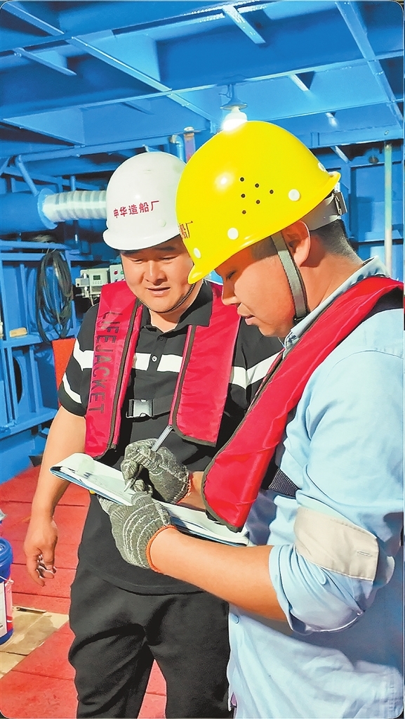 刘彬（左）和同事对船舶进行安全检查。越来越多的人选择扎根河南、深耕水运。记者 林栋 摄