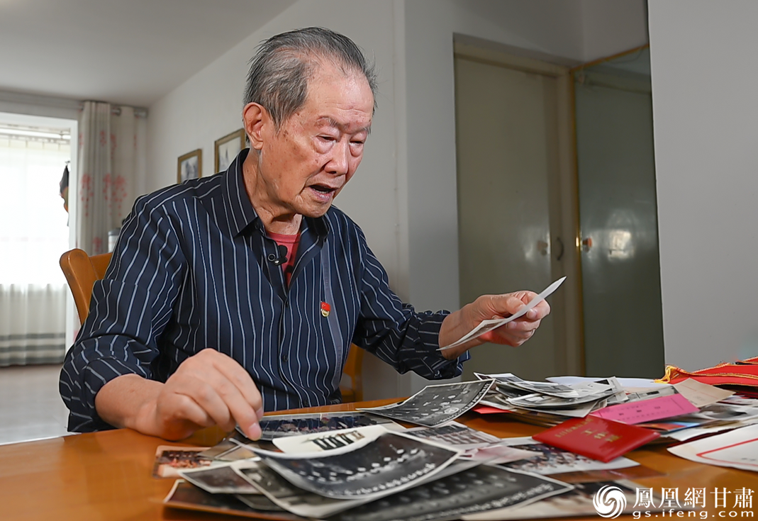 吴培赓翻阅珍藏的老照片，回忆与王进喜在一起的点滴。