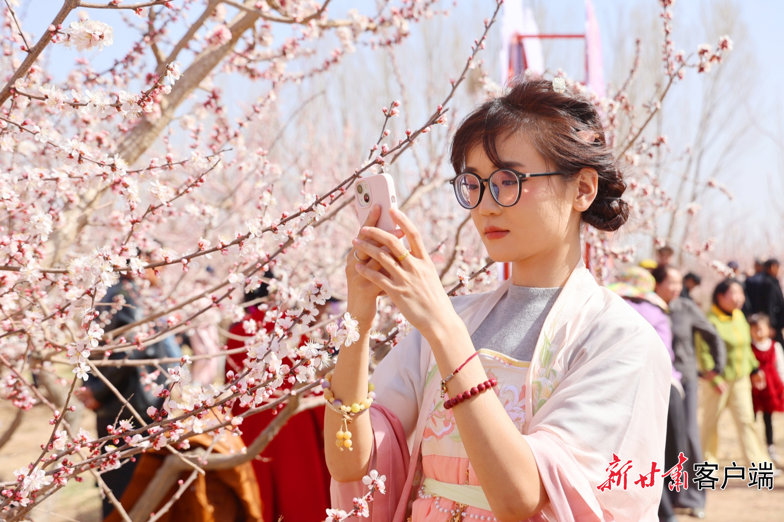 当地游客走进杏园赏春景