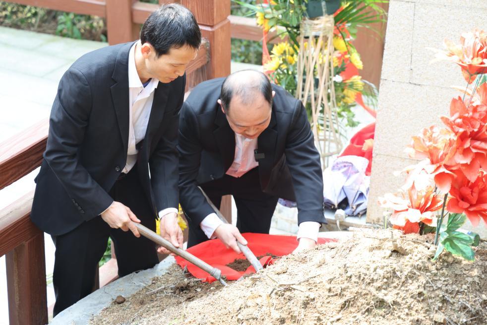 3月26日，江西瑞金“寻亲工作队”在烈士墓前取土，用红布包裹带回瑞金。新华社发（刘翔宇 摄）