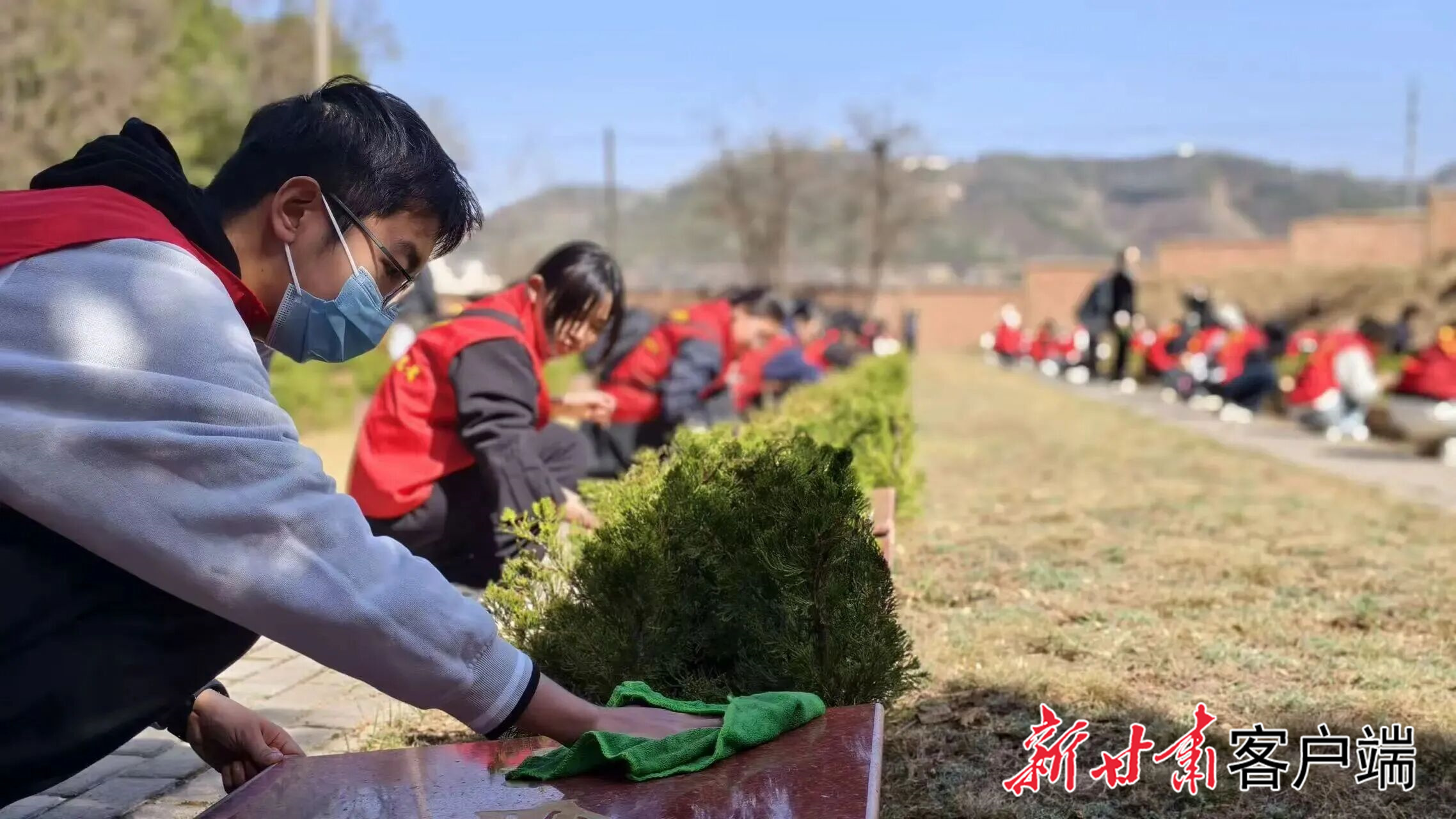 在兰州烈士陵园，青年擦拭无名烈士碑。（团省委供图）