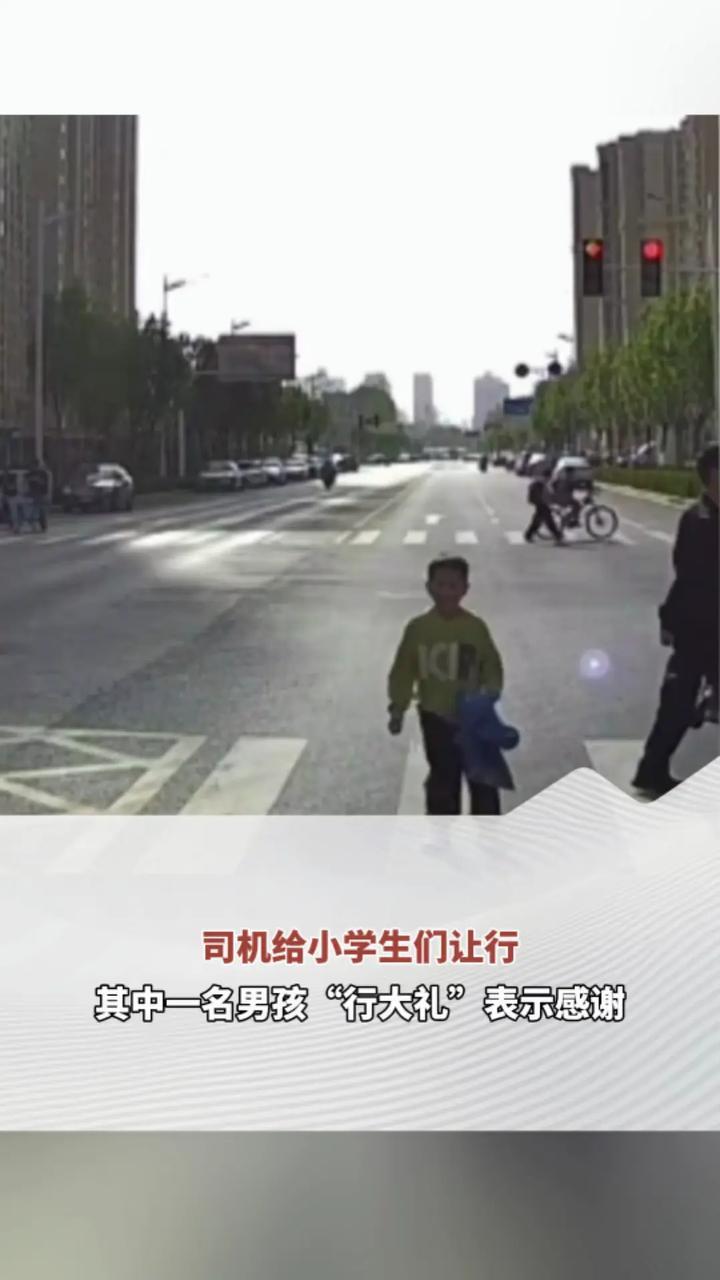 司机给小学生们让行 其中一名男孩“行大礼”表示感谢