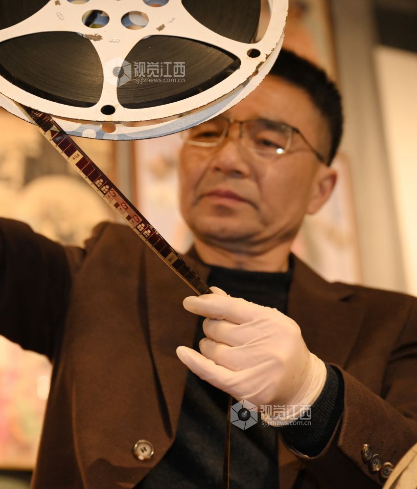 张赛祥认真打量着电影胶片。