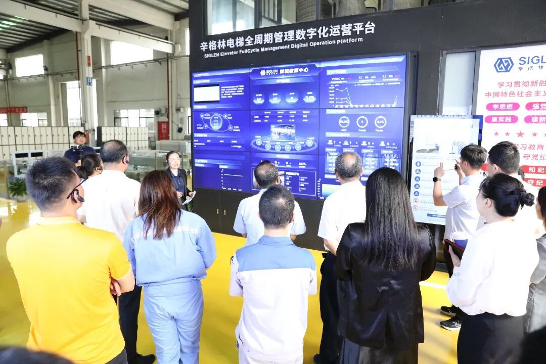 图：与会人员走进辛格林电梯的智能化制造车间