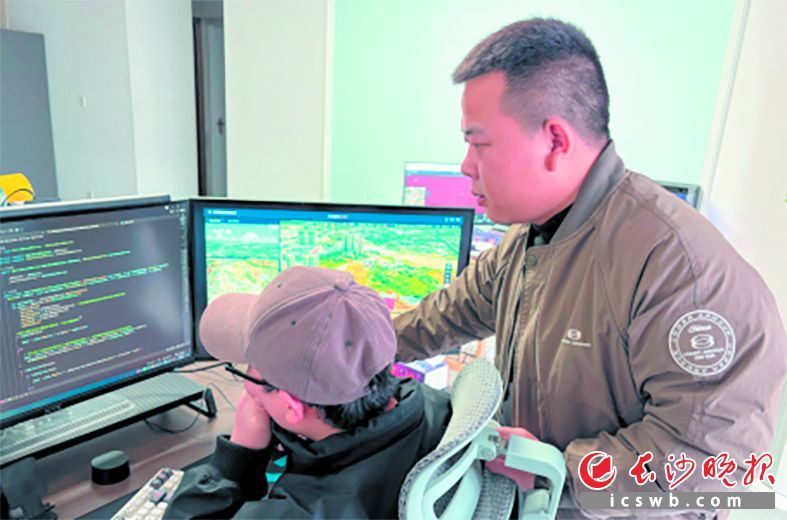 尹靖城(右)和团队成员在探讨技术问题。长沙晚报全媒体记者 何文瑞 摄