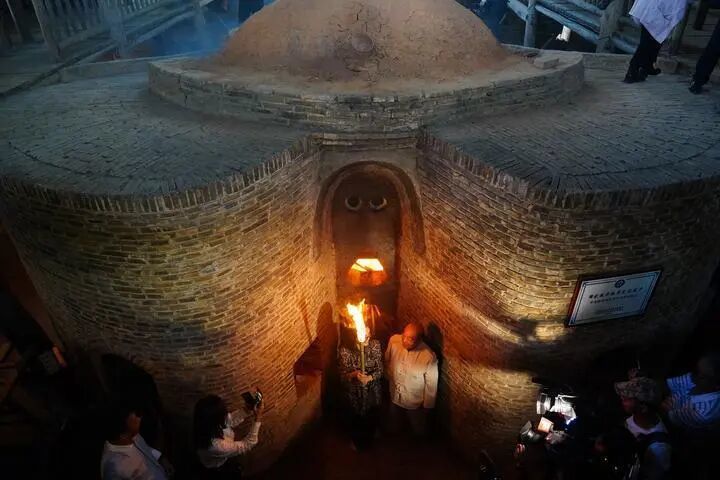 与会嘉宾与烧窑把桩师傅胡家旺一起为葫芦窑复烧点火。新华社记者周密摄