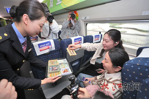 “春游”列车上,工作人员向旅客发放小礼品。