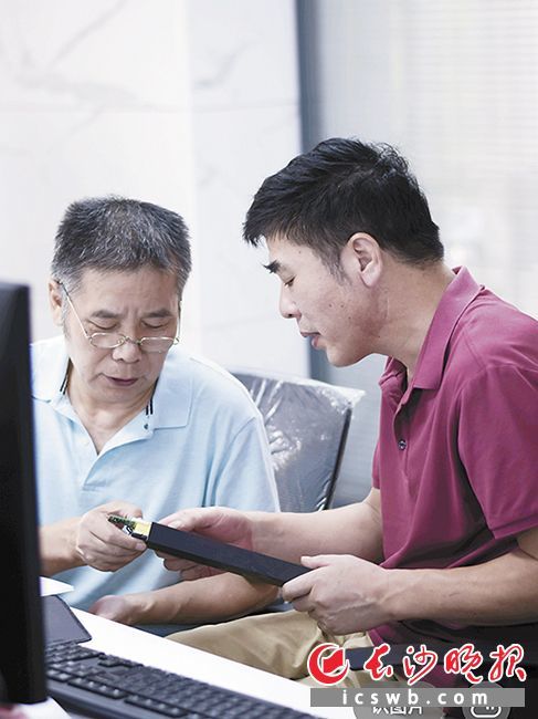 谢文超（右）和同事一起研究产品。