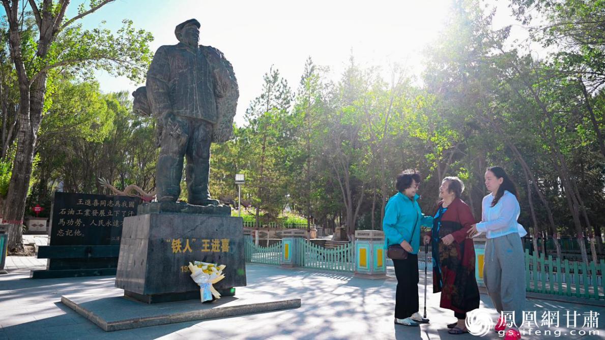 邓定维（中）向老战友王进喜献花　张修毅　摄