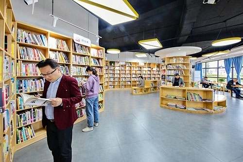 市民在萍乡市湘东区龙舟公园“书香驿站”阅读书籍。