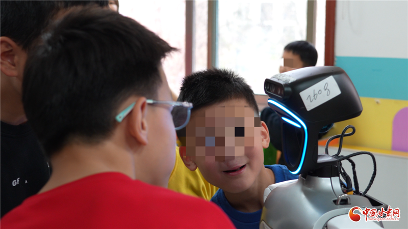 图为孩子们与机器人热情互动交流