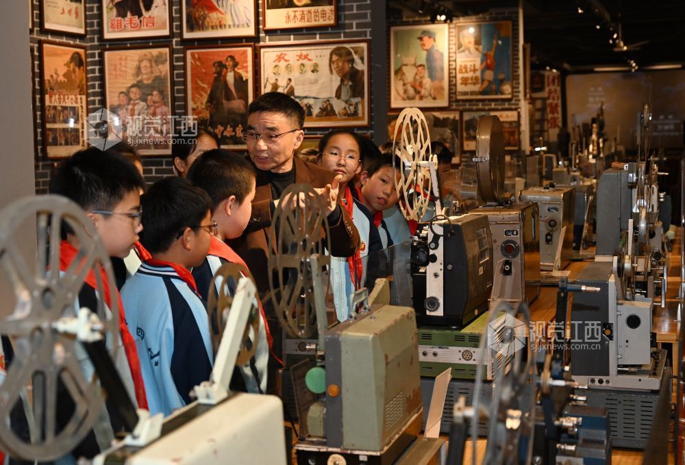 张赛祥向前来研学的学生介绍电影放映机的工作原理。