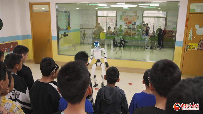 图为中国移动自研人形机器在福利院向孩子们做自我介绍