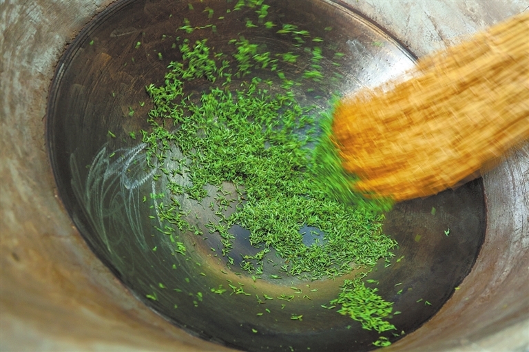 手工炒制茶叶。