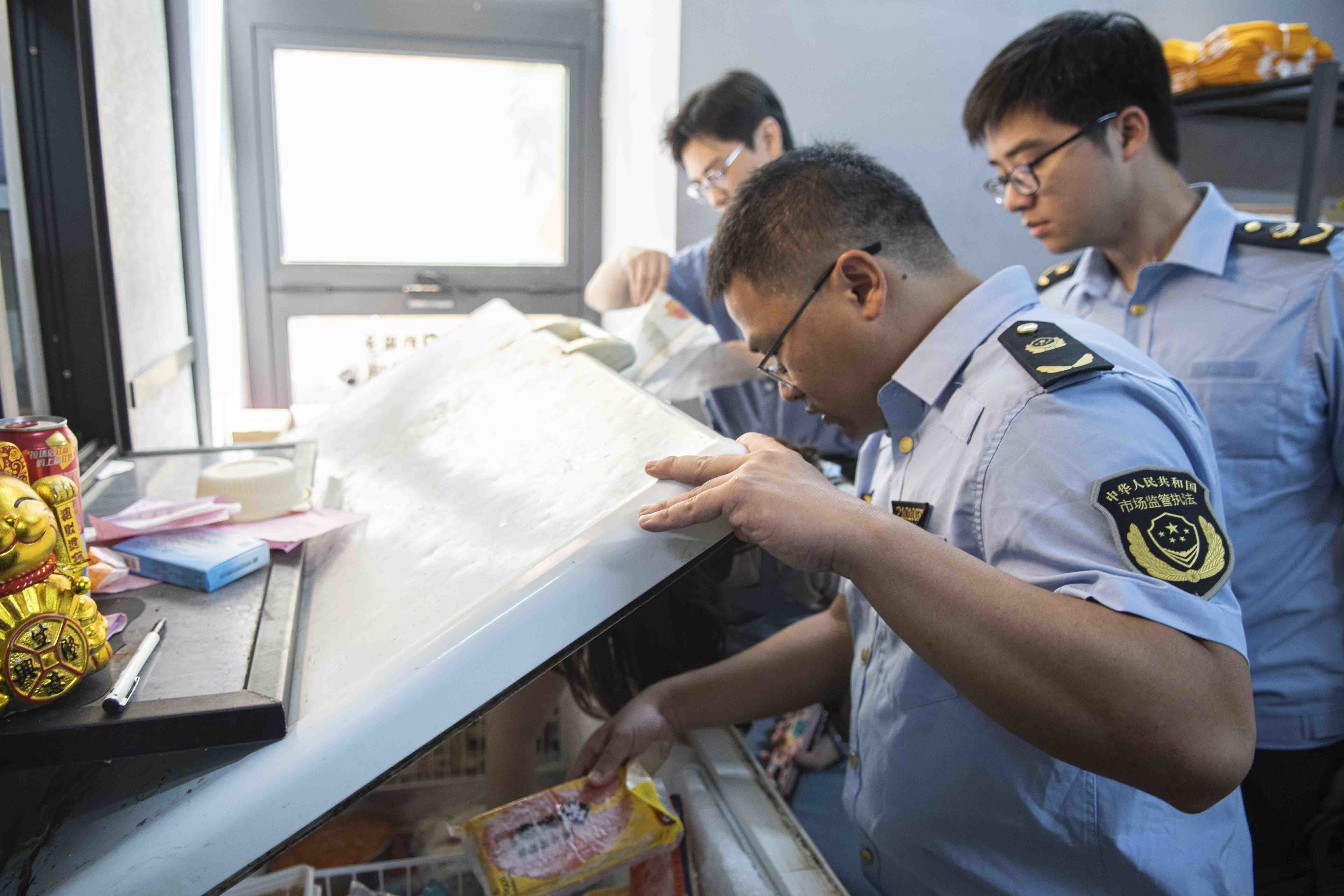 执法人员对线下餐饮实体店进行检查。记者 蒙健 摄