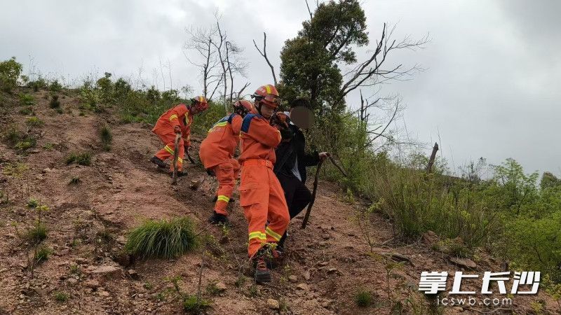 消防员搀扶体力透支男子下山。 均为长沙晚报通讯员 王磊 供图