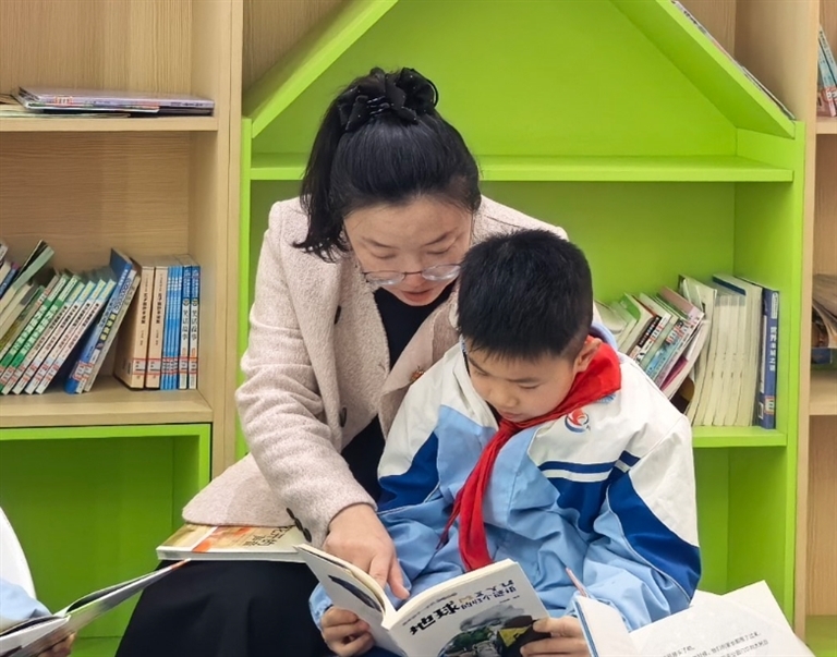 张伟霞在校园阅读角陪伴学生阅读。本报全媒体记者 钟剑桥摄