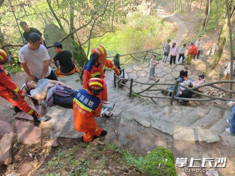 消防员用担架救助崴脚女子。
